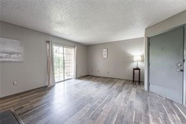 Unfurnished living room featuring a textured ceiling and wood finished floors | Image 5