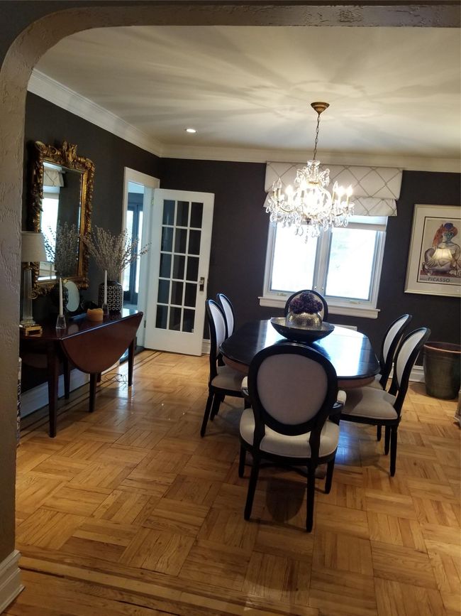 Dining room featuring crown molding, a notable chandelier, and arched walkways | Image 5