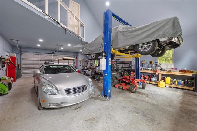 Garage featuring a garage door opener and a workshop area | Image 34