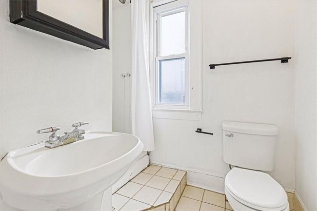 Bathroom featuring tile patterned floors, sink, toilet, and a healthy amount of sunlight | Image 14