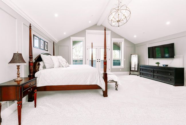 Bedroom with vaulted ceiling with beams, carpet, and french doors | Image 27