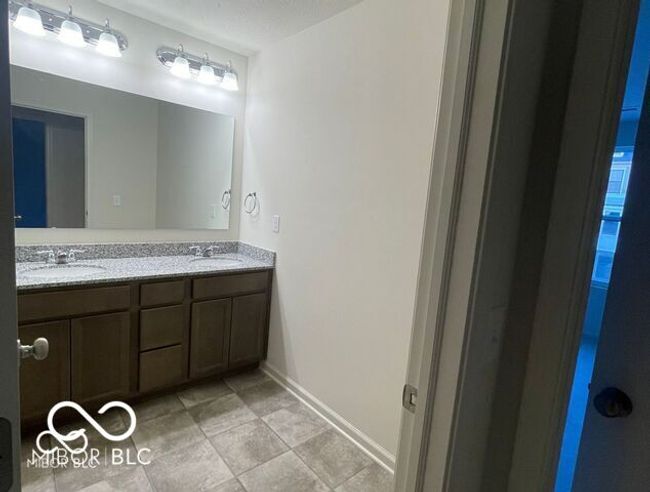 full bathroom with a sink, tile patterned floors, baseboards, and double vanity | Image 19