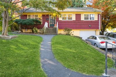 View of front of home featuring a front lawn and a garage | Image 1