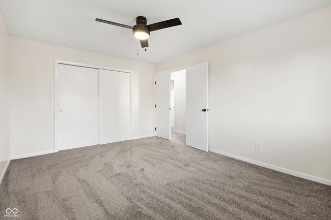 unfurnished bedroom featuring baseboards, a ceiling fan, carpet floors, and a closet | Image 21