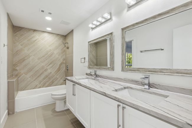 Full bathroom featuring tile patterned flooring, toilet, visible vents, and a sink | Image 28
