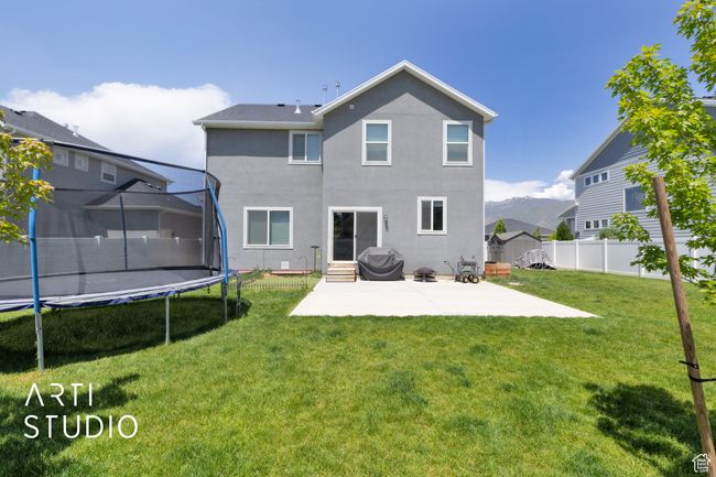 Back of property with a trampoline, a patio, stucco siding, and entry steps | Image 31