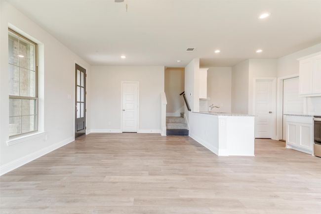 Kitchen featuring white cabinetry, sink, light stone countertops, and light hardwood / wood-style floors | Image 9