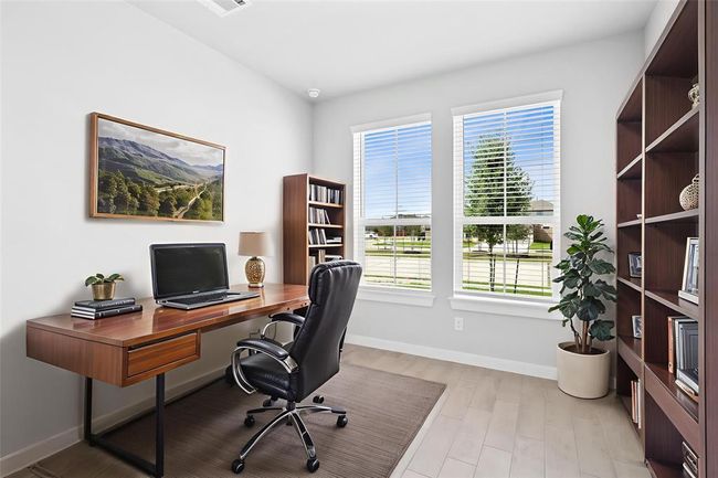 Quietly nestled in front of the home is the study/home office. Featuring wood look tile flooring, high ceilings, large windows with privacy blinds, closet space, French doors, and custom paint. | Image 4