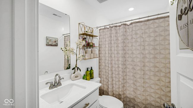 full bath with vanity, toilet, and a shower with shower curtain | Image 10