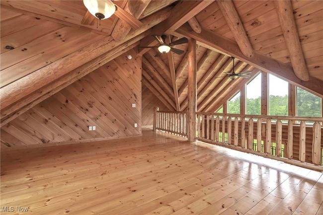 View of angled ceiling in the loft, overhead ceiling fan with light | Image 22