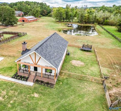 Overhead view of the house with the barn, pasture, and pond in the distance. | Image 1