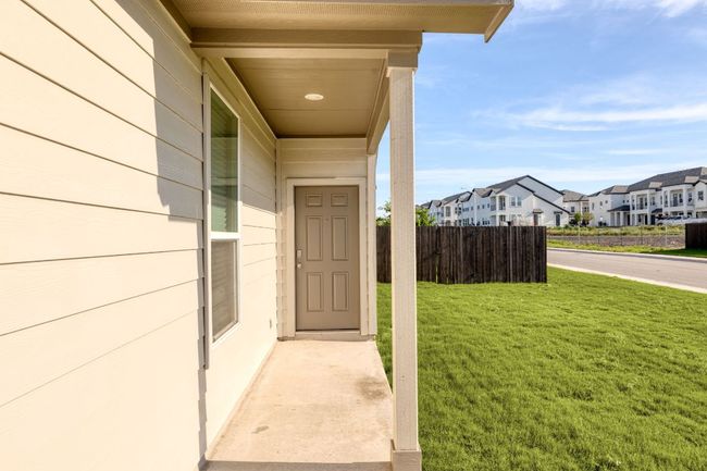 Doorway to property featuring a lawn, fence, and a residential view | Image 8