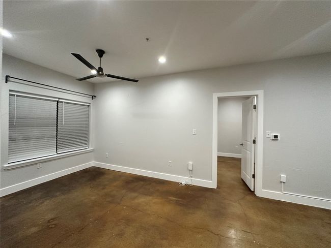 Empty room with concrete floors, a ceiling fan, and recessed lighting | Image 5