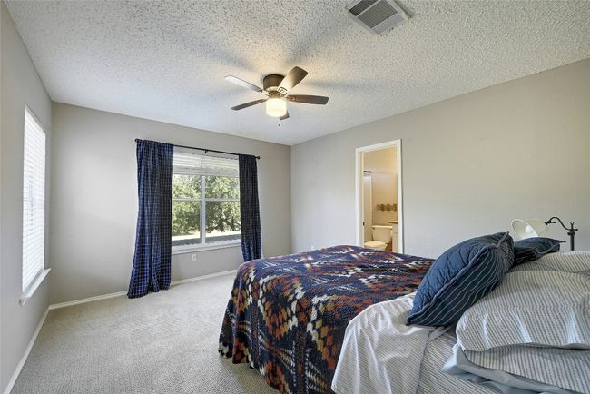 Bedroom featuring carpet floors, a ceiling fan, and a textured ceiling | Image 18
