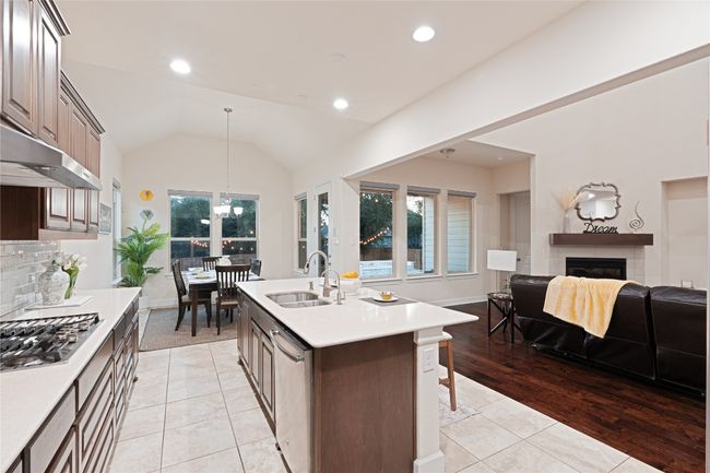 Kitchen with stainless steel appliances, open floor plan, light countertops, healthy amount of natural light, and lofted ceiling | Image 16