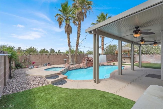 View of swimming pool featuring a fenced backyard, a ceiling fan, a pool with connected hot tub, and a patio | Image 36
