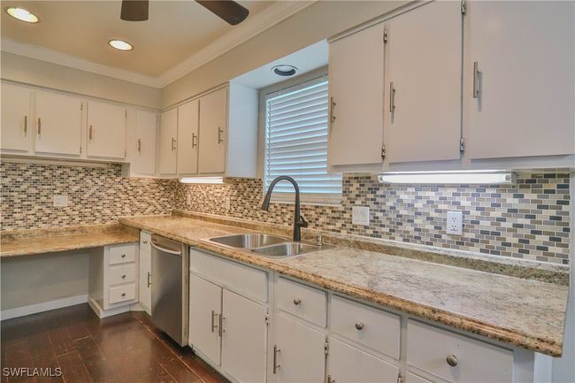 Kitchen with a sink, stainless steel dishwasher, ornamental molding, a ceiling fan, and dark wood-style flooring | Image 24
