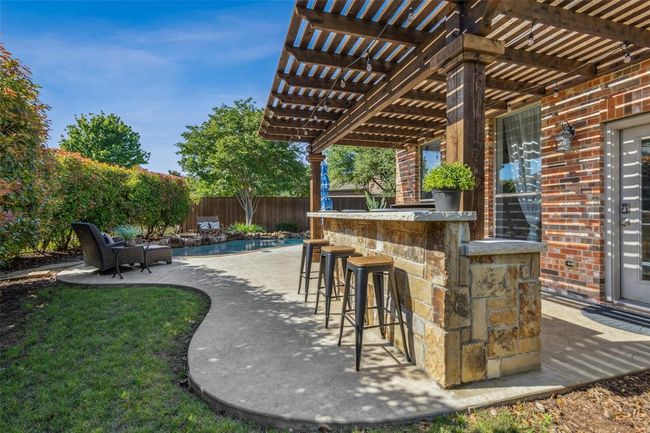 View of patio with exterior bar, a pergola, and a fenced in pool | Image 28
