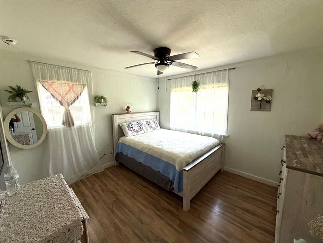 Bedroom featuring a textured ceiling, dark wood-type flooring, and a ceiling fan | Image 22