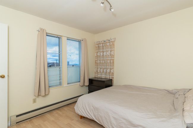 Bedroom featuring a baseboard heating unit and wood finished floors | Image 24
