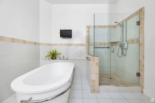 Full bathroom with a stall shower, a tub to relax in, and tile walls | Image 15