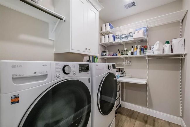 The main utility room features lots of storage space, cabinets and a folding table. | Image 23