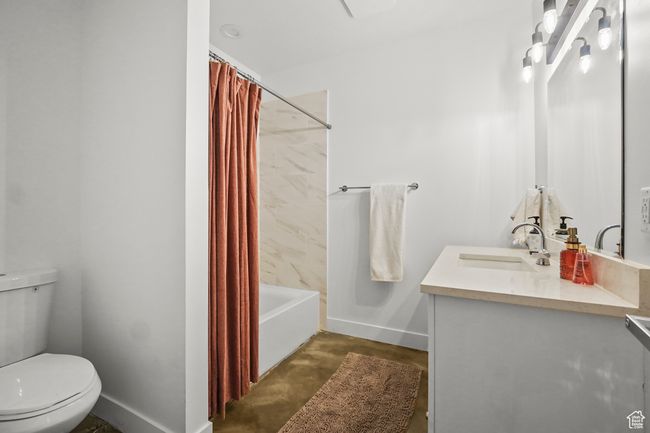 Full bath featuring vanity, shower / bath combination with curtain, and concrete floors | Image 32