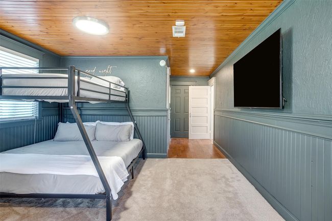 Carpeted bedroom with ornamental molding, wooden ceiling, and a wainscoted wall | Image 27