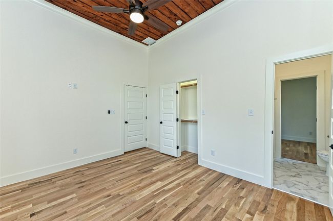 Unfurnished bedroom featuring wooden ceiling, light wood-style floors, and a towering ceiling | Image 20