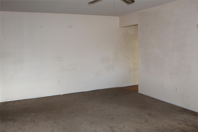 Ceiling fan and dark carpet overlooking front of building | Image 11