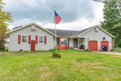 Ranch-style house with a garage and a front lawn | Image 1