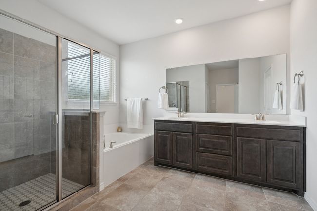 Full bathroom featuring a garden tub, a shower stall, and double vanity | Image 17