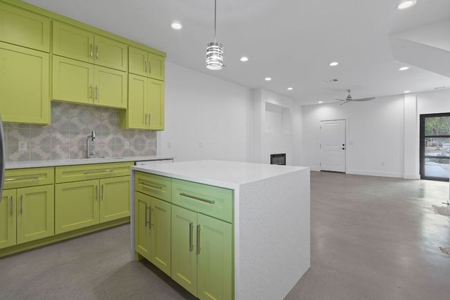 Kitchen with green cabinets, light countertops, recessed lighting, and decorative backsplash | Image 11