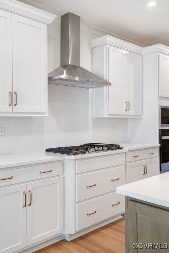 Photo represents the plan, not the actual home. Design selections may vary. A spacious kitchen with an island and pantry open to an adjoining dining area and the family room. | Image 8