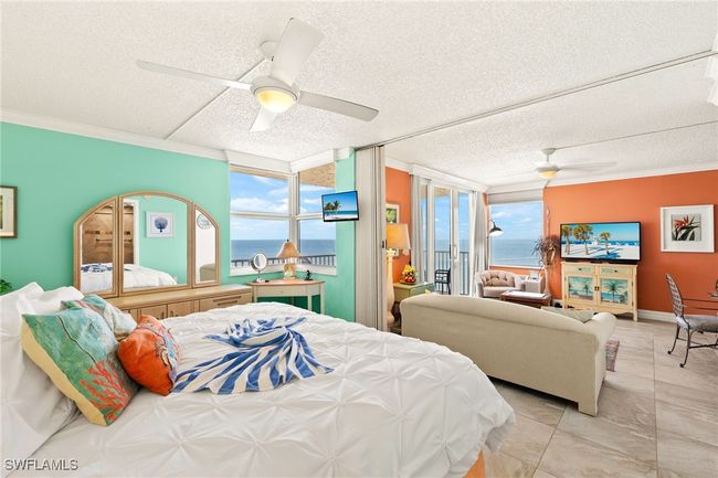 Bedroom with crown molding, a textured ceiling, a ceiling fan, and access to outside | Image 14