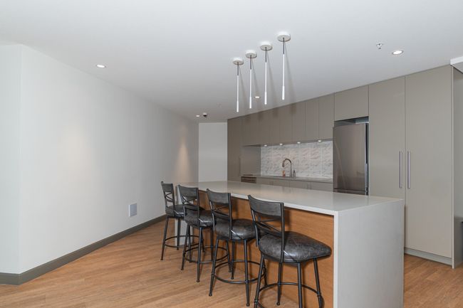 Kitchen featuring freestanding refrigerator, gray cabinetry, modern cabinets, light wood-style flooring, and a sink | Image 36