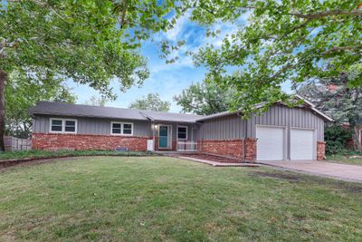 Ranch-style house featuring a garage and a front lawn | Image 1