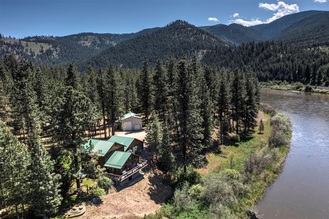 View of mountain backdrop with a heavily wooded area and a nearby body of water | Image 75