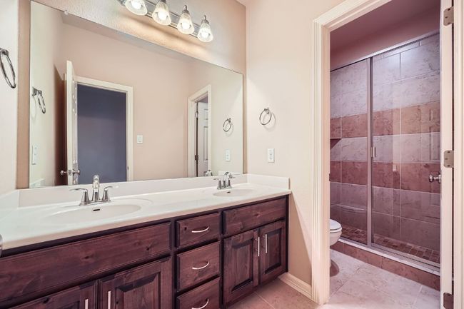 Full bath featuring double vanity, a stall shower, and tile patterned floors | Image 23