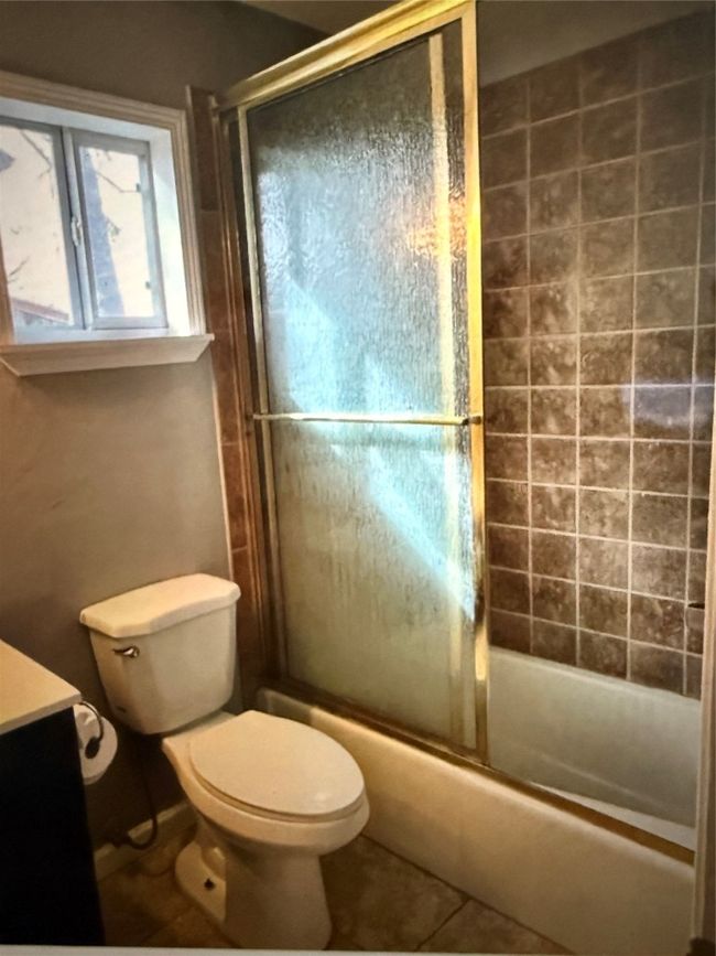 Bathroom featuring vanity, enclosed tub / shower combo, and tile patterned floors | Image 14