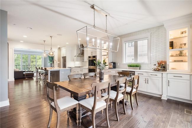 Bright Dining area contains built-in beverage bar with mini fridge, tiled wall and 2 lighted display cabinets. | Image 13