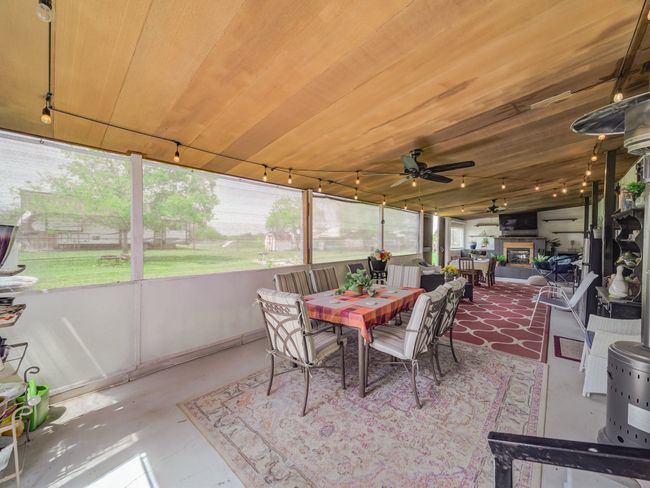 Covered outdoor living with fireplace, house one. | Image 16