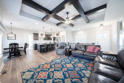 Living room with light hardwood / wood-style floors, coffered ceiling, beamed ceiling, and ceiling fan | Image 3