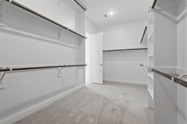 Spacious closet featuring light colored carpet and visible vents | Image 21