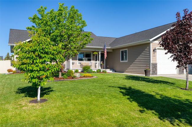 View of front of house featuring a garage, covered porch, a front lawn, concrete driveway, and a shingled roof | Image 4