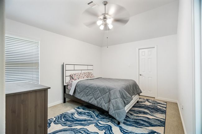 Bedroom with light colored carpet and a ceiling fan | Image 33