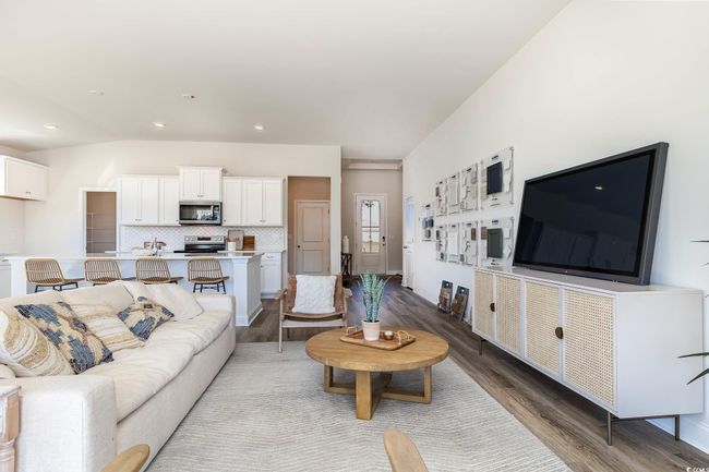 Living room with vaulted ceiling and wood finished floors | Image 18