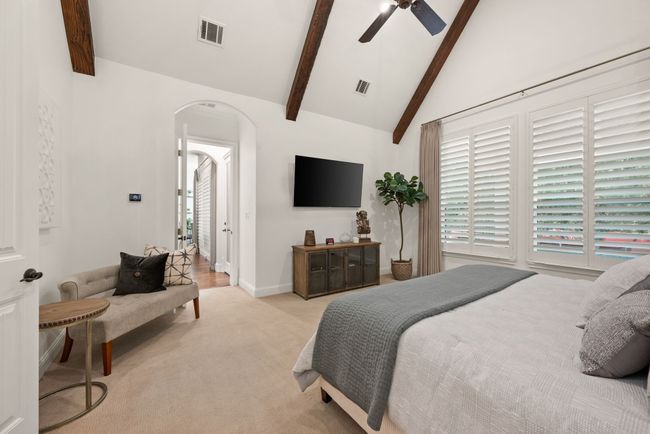 Primary Bedroom Suite with arched entry hall, light carpet, vaulted ceiling with fan and exposed beams | Image 18