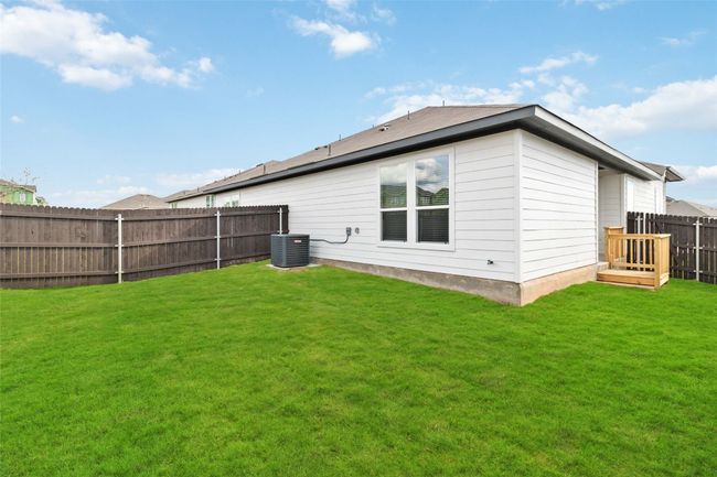 Rear view of property with central AC unit, a lawn, and a fenced backyard | Image 4