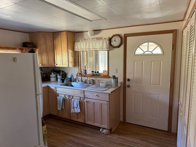 Kitchen featuring freestanding refrigerator, light countertops, and dark wood-style flooring | Image 11